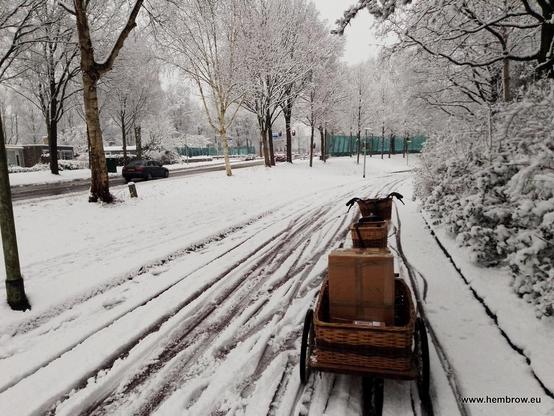 Bicycle pulling a trailer on a Dutch cyclepath. Unfortunately the snow plough hasn't been along here for a while so it's not easy cycling.