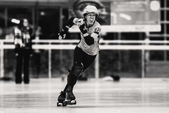 A black and white picture of a Roller Derby jamming person