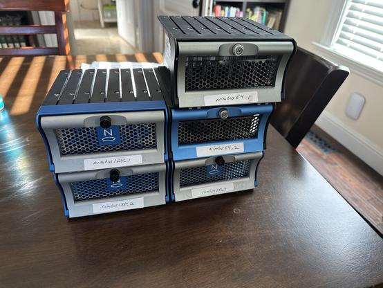 Front of the 5 Solid State Packs. These are assembled into packs of 8, the container has a Nimbus logo, a handle, and the frame has the 8 SSDs screwed in.