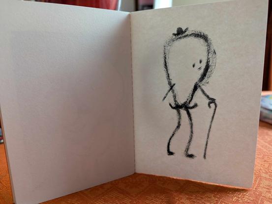 Petit cahier brut avec une série de dessins intuitifs et spontanés dessinés au feutre pinceau noir.