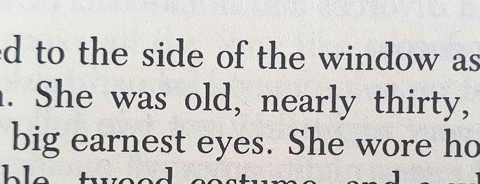 Close-up of a line in the book, which reads: "She was old, nearly thirty, ..."
