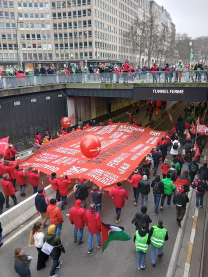 Grand tifo de manifestation tenu par une vingtaine de personnes, qui passent dans une tunnel fermé à la circulation