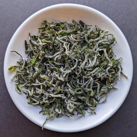 Some organic "green spring snail" bi luo chun green tea in a white porcelain dish