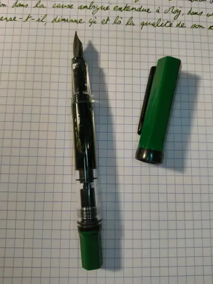 Picture of the "twisbi" eco. The cap and the other end are green, the nib and the clip are black, and most of the pen is transparent, so we can see the ink inside.