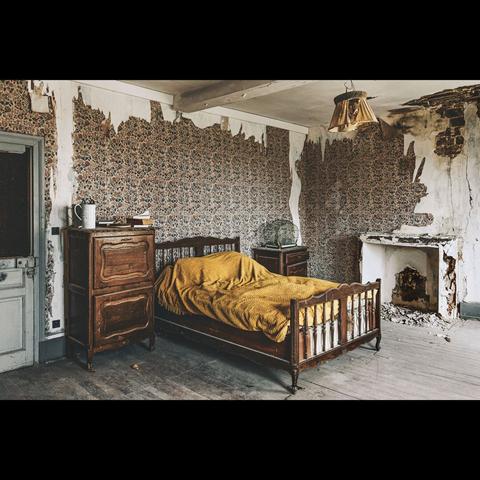 Urbex photography in color , vintage style : Exploration of a bedroom with an old bed and a broken fireplace in an abandoned castle