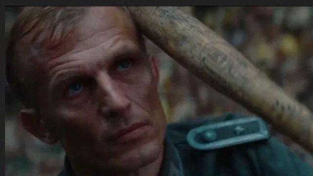 Scène uit de film “Inglourious Basterds”.   Donny 'De Beer Jood' Donowitz (lid van The Basterds), streelt zachtjes een honkbalknuppel over het hoofd van Wehrmacht sergeant Werner Rachtman.  (hier afgebeeld is het moment vlak voordat de Duitser op brute wijze wordt vermoordt.)