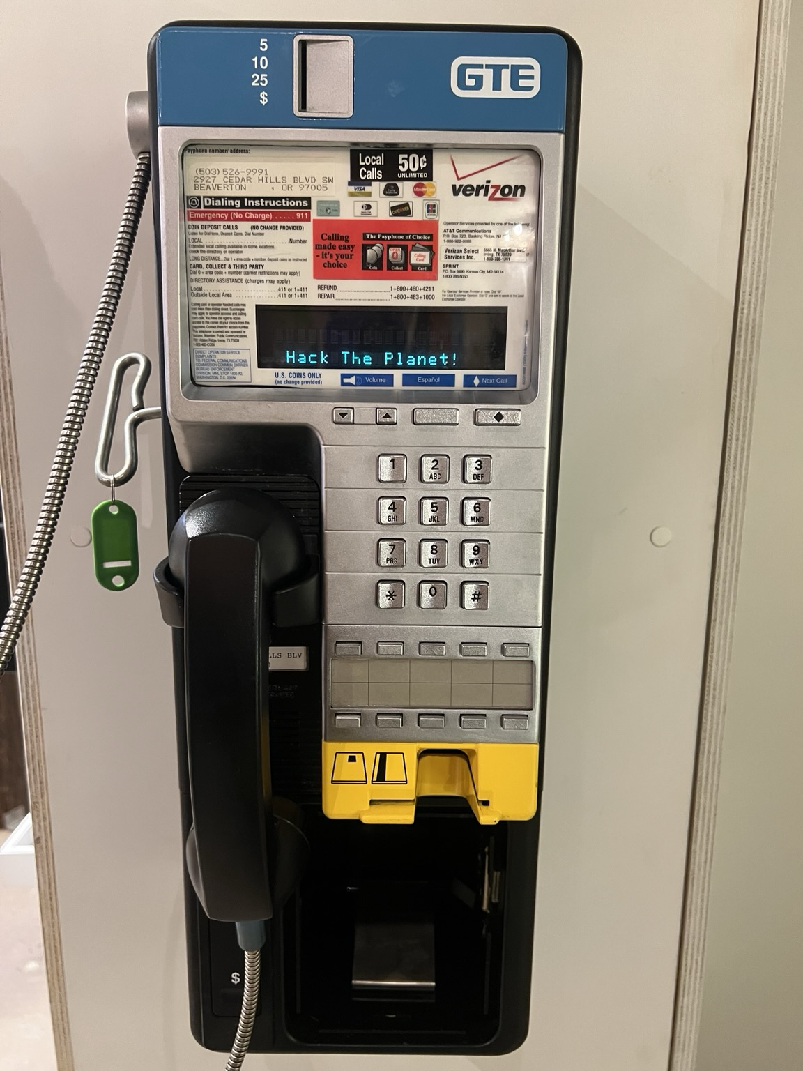 A photo of a Nortel Millennium payphone. On the screen are the words “hack the planet”