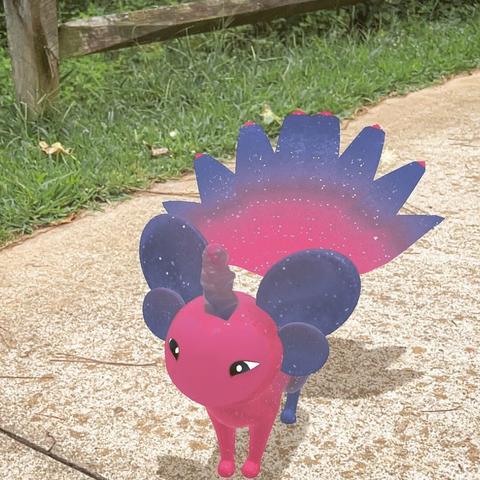 A pink and dark blue Peridot creature standing on the walkway at a park.