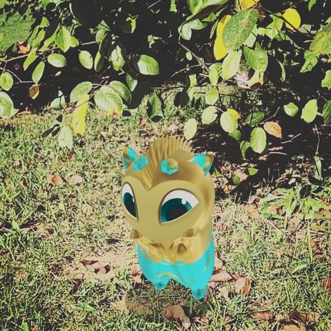 A yellow and light blue dot standing on its hind legs in front of a bush.