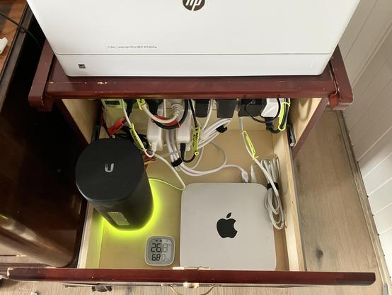 A filing cabinet drawer repurposed as a network cabinet with a power board, router, and Mac mini server.
