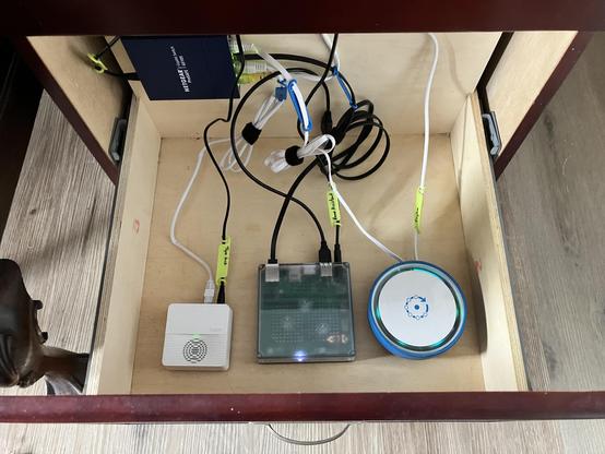 A filing cabinet drawer repurposed as a network cabinet with a small switch, Tapo hub, Home Assistant Green, and Fingbox.