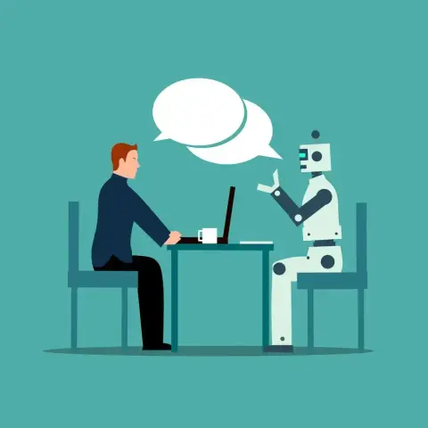 Eine Person, die mit einem Bot am Tisch sitzt und redet.