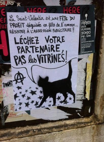 Un chat noir, marchant sur des étoiles dit : "La Saint Valentin est une fête du profit déguisée en fête de l'amour... résistez à l'agression publicitaire !!
Léchez votre partenaire, pas les vitrines !"
