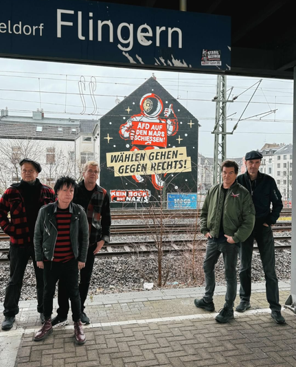 Die Hosen am S-Bahnhof Flingern vor einem Hausgemälde "Geht wählen gehen rechts".