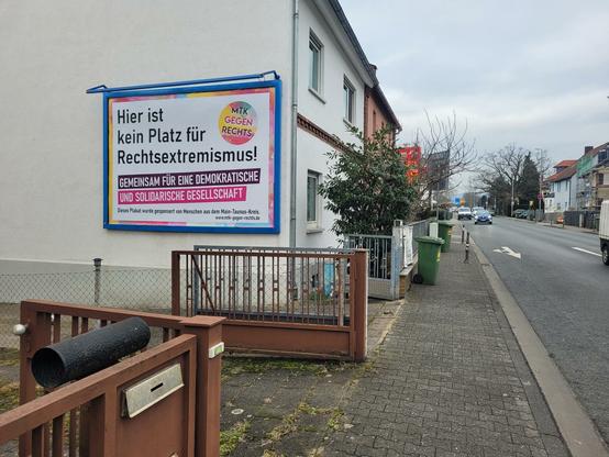 An einer Hauswand ein Plakat mit der Aufschrift "Hier ist kein Platz für Rechtsextremismus – Gemeinsam für eine demokratische und solidarische Gesellschaft.