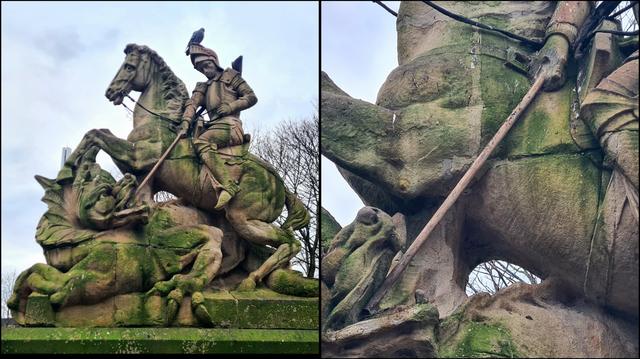 A statue of St George fighting a dragon. His missing lance has been replaced with a wooden broon handle.