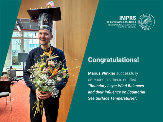 Marius Winkler wearing a PhD hat and holding a flower bouquet.
