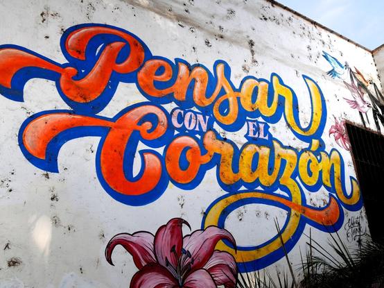 The lettering ‘Pensar con el Corazón’ in colourful, curved letters as graffiti on a wall