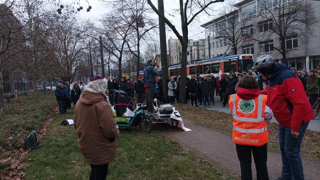 Mitja steht auf einem Fahrradanhaenger und spricht ueber Waermenetze.