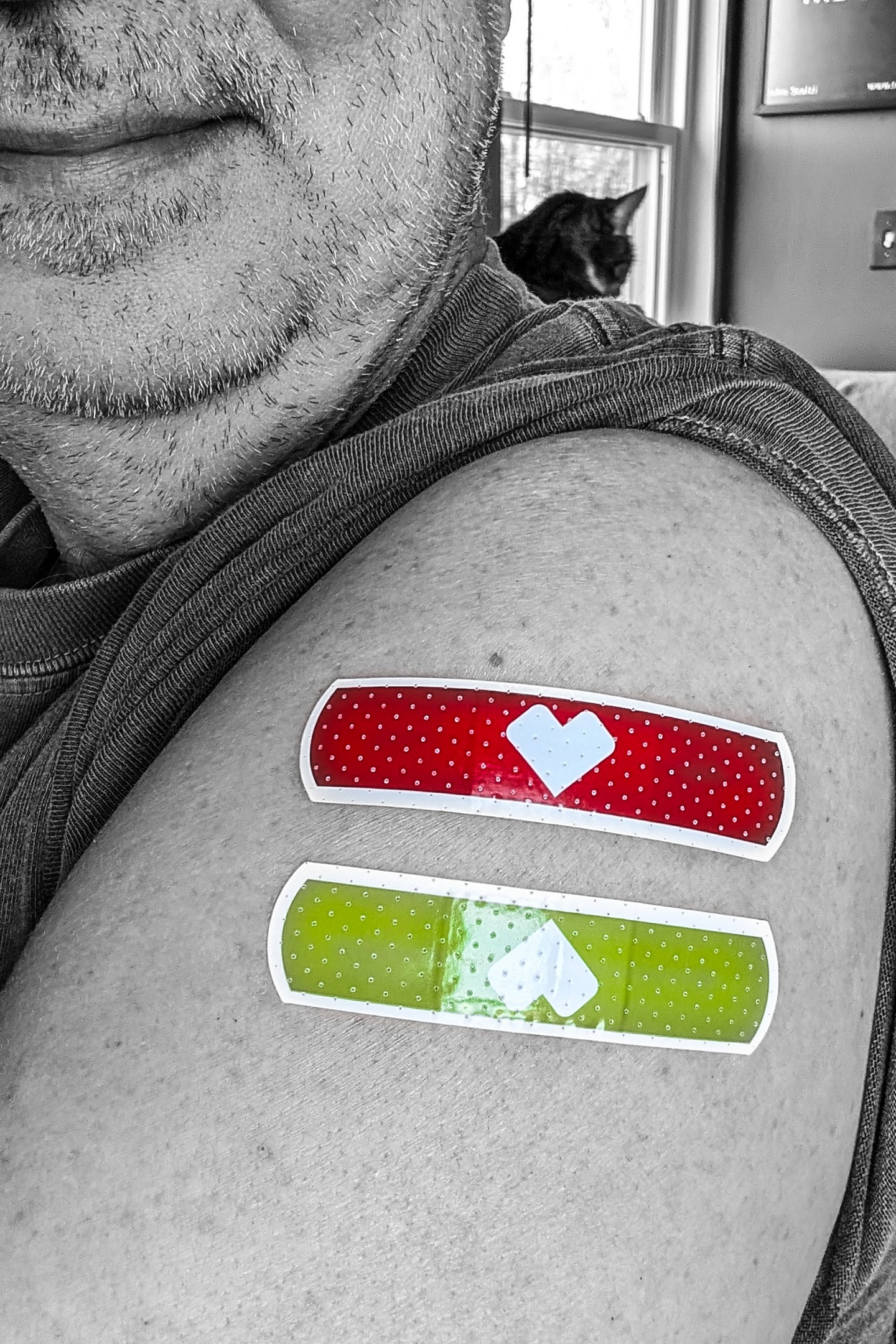 Me with two bandaids on my left arm, one for each injection site.