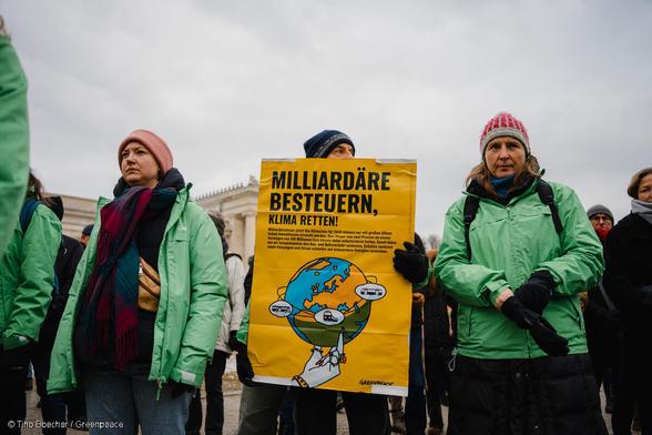 Greenpeace-Aktive protestieren auf dem Klimastreik für eine umweltbezogene Milliardärssteuer.