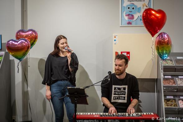 Two persons singing and playing music.