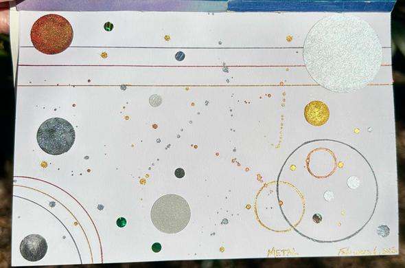 Same collage at an angle, with sunlight catching all the metallic ink and making it sparkle.