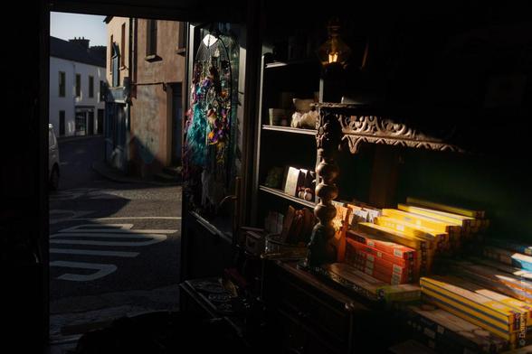 A view from inside a shop in Bantry, Co Cork, looking out onto the street; hanging decorations are visible to the left, shelves of boxes and other items to the right, and the street in the background.