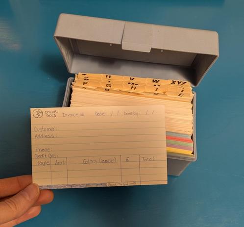 A handwritten invoice form on an index card, meant for taking orders for custom friendship bracelets. At the top is a "CG" logo for Color Gold, a space for the invoice number, date, and due date. There are lines for customers' names, addresses, phone numbers, and credit card number, despite the fact that I was a child and had no way to process credit cards. At the bottom, spaces for bracelet style, amount, colors (in order), cost, and price, along with a grand total line at the bottom. I clearly put a lot of thought into this.

I am holding this historical relic over an index card file box, in which it - along with several others like it - had been sorted under "I" for "invoice".
