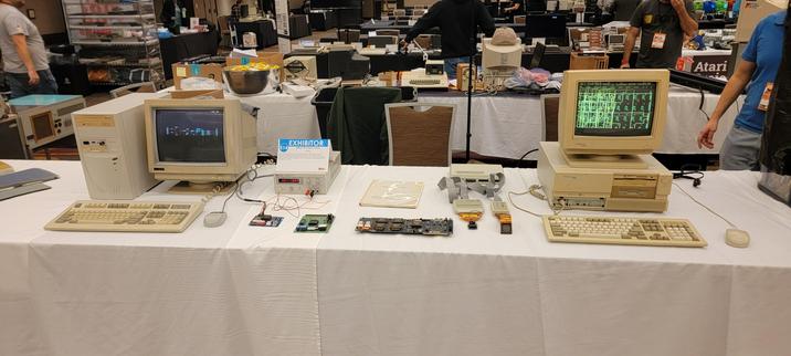An exhibit table at a vintage computer festival with two PCs running Xilinx X-ACT v2.12 and v4.