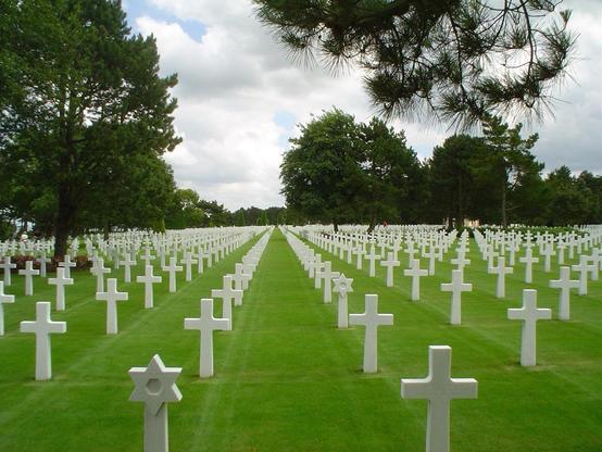 Eine grüne Wiese mit den Grabkreuzen und David-Sternen von US-Soldaten, die 1944 bei der Landung in der Normandie getötet wurden