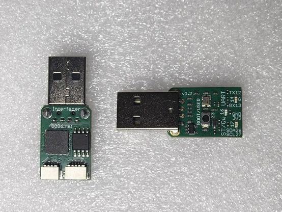 A small PCB with USB Type-A plug on one end and two small JST compatible connectors on the other (3-pin UART, 4-pin I2C). To the side is the same board but reversed showing a button, LED and other components.