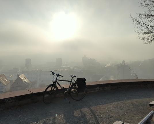 Fahrrad auf Aussichtsplattform Birkenwaldstraße bei Nebel, kurz bevor die Sonne durchbricht
