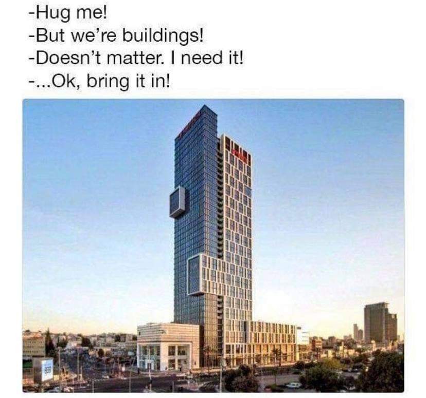 Text at the top:  "- Hug me! - But we're buildings! - Doesn't matter. I need it! - ...Ok, bring it in!" Below the text, there is an image of a tall, modern skyscraper. The building is made of glass and steel, with sections jutting out, creating an illusion of two separate structures that look like they are embracing. The skyline is clear, and the sun appears to be setting, casting warm light on the scene.