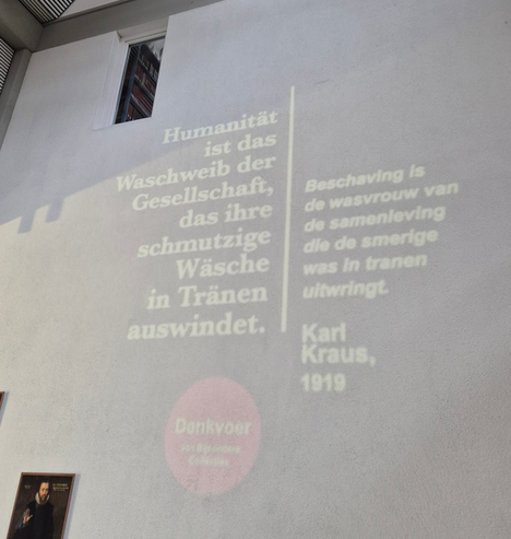 Citaat van satiricus Karl Kraus, geprojecteerd op binnenmuur van de UB Groningen. 

Tekst in Duits: 

Humanität ist das Waschweib der Gesellschaft, das ihre schmutzige Wäsche in Tränen auswindet.


Tekst in Nederlands: 

Beschaving is de wasvrouw van de samenleving die de smerige was in tranen uitwringt