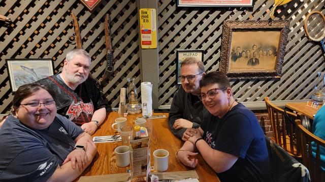 Arianna, Peter, Mark, & Dora sitting at a Cracker Barrel table.