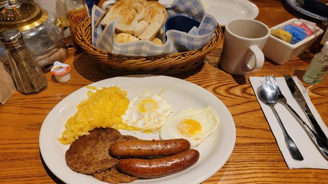 Cracker Barrel Breakfast of Toast, Eggs, Hashbrown Casserole, Impossible Sausage, Spicy Chicken Sausage, with Coffee.