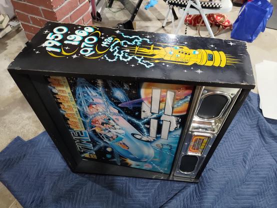 Time machine's backbox detached and sideways on a moving blanket