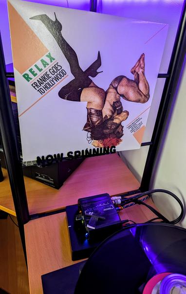 Turntable spinning 45rpm expended mix of Relax. The cover is in the background. It depicts equal-opportunity sexual bondage. Actually, given the position and restraints, it's no-opportunity sexual bondage, just equally applied.
