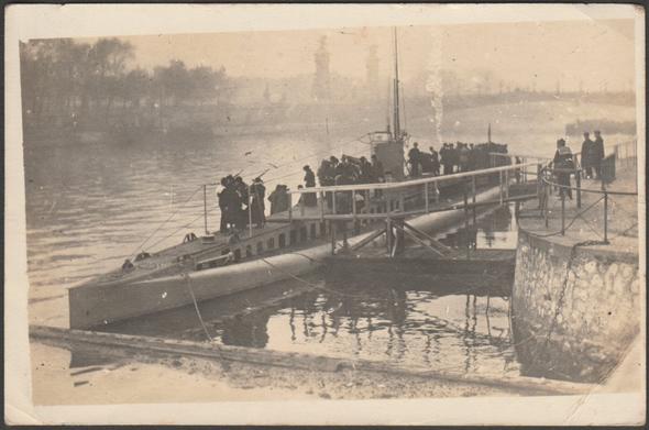 Sepia real photographic postcard showing a view of the French submarine Montgolfier in November 1918, moored near the Pont de la Concorde in Paris. The visit took place from the end of October 1918 to the 1st of January 1919 and was intended to convince the populace to subscribe to the Loan of Liberation. Subscribers were allowed to visit the deck of the submarine.
Publisher not stated, not numbered, 1918.
Postally unused, but with lengthy message, dated 12 January 1919.
Good condition, with some corner bumps, but crease to bottom right corner and small creases to top right and bottom left corners.