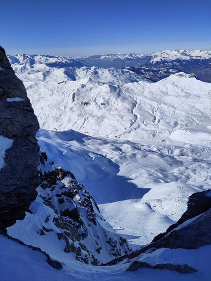 Foto. Berglandschaft mit Schnee, im Vordergrund ein Couloir.