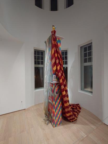 A multicoloured sculpture with a drape and mr. Burns on top.