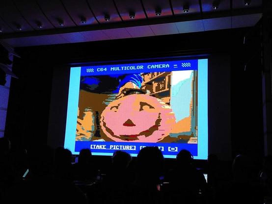 A photo of a pumpkin on a small fake screen on a big screen