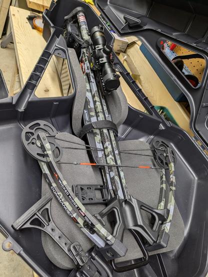 A crossbow rests in a hard shell carrying case.