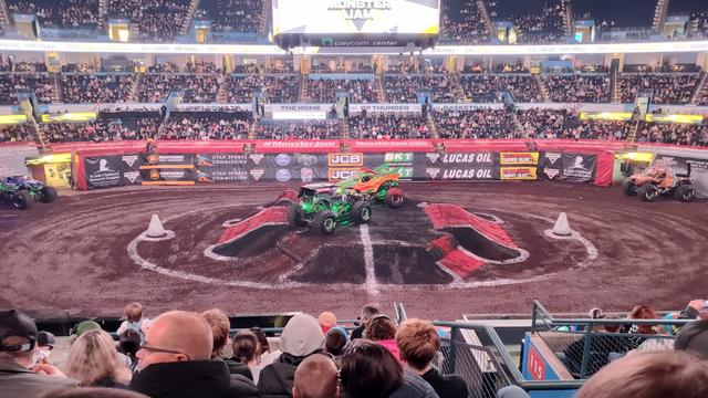 The Dragon and Grave Digger trucks fighting for dominance in the middle of the arena, on top of the center stunt platform
