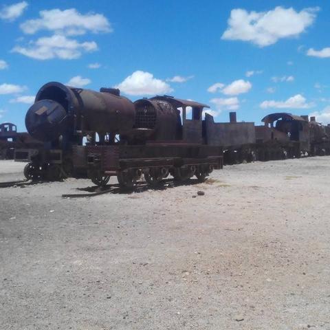 Photo of a rusted and abandoned locomotive and wagons attached to it