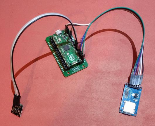 An RP2040 Pi Pico in a mini breakout board with a micro SD card module and a KY-004 reset switch, both connected with Dupont cables.
