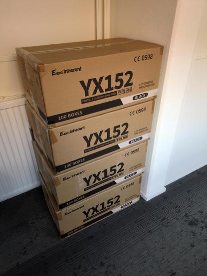stack of four big cardboard boxes containing 1000 black FFP2 masks each