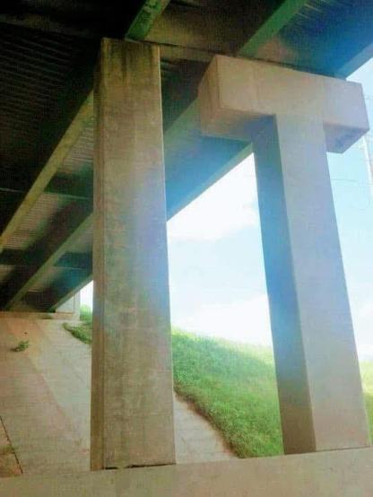 Concrete pillars under a bridge look like capital letters I and T.
