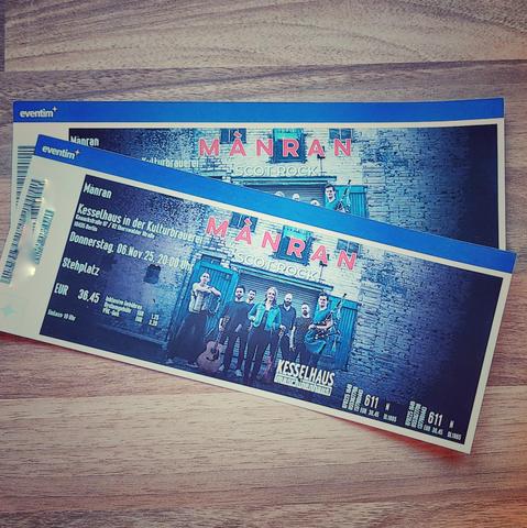 Photo of two concert tickets for the Band Mànran. On the tickets you see a photo of the band standing in front of an old industrual building.